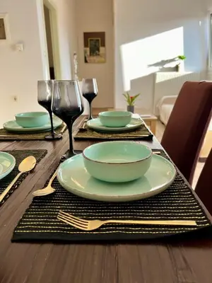 a wooden table with plates and forks and wine glasses at Stratos Apartment in Chania Town