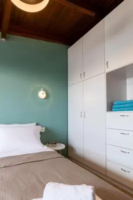 a bedroom with a bed and a blue wall at Alpha delight apartment 3 bedroom in Chania Town