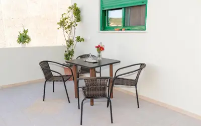 a table with four chairs and a table with flowers on it at Xirouchakis farm2 in Kissamos