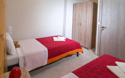a hotel room with a red bed and a bathroom at Xirouchakis farm2 in Kissamos