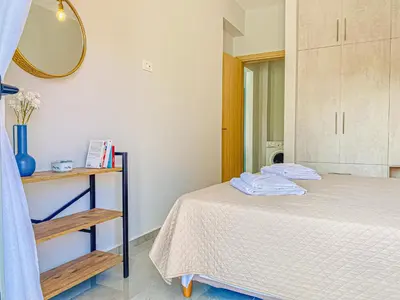 a bedroom with a bed and a mirror at Newly Built House Steps from the Beach: Everything Within Walking Distance - Enjoy a Car-Free Stay in Agia Marina Nea Kydonias