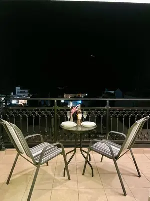 a table with two chairs and a table with flowers on a balcony at Sea View Apartment #1 in Ayiá