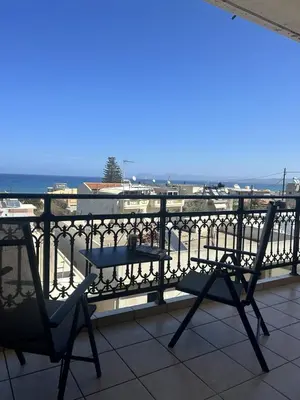 a balcony with a table and chairs and the ocean at Sea View Apartment #1 in Ayiá