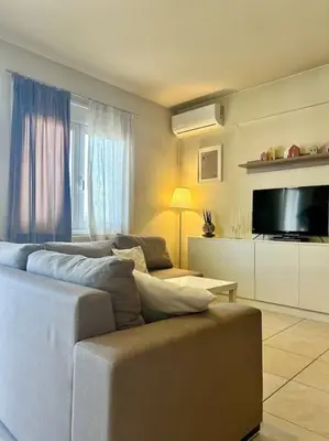 a living room with two couches and a flat screen tv at Sea View Apartment #1 in Ayiá