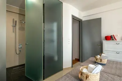 a bathroom with a green shower stall and baskets at s - plazza residence in Chania Town