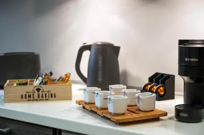 a group of coffee cups on a wooden tray on a counter at s - plazza residence in Chania Town