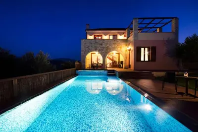 a swimming pool in front of a house at night at Villa Katerina with Eco heated pool in Spiliá