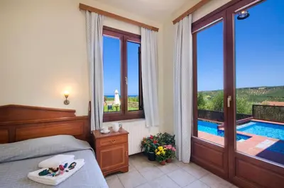 a bedroom with a bed and a swimming pool at Villa Katerina with Eco heated pool in Spiliá
