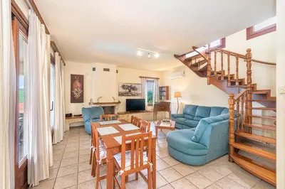 a living room with a blue couch and a table at Villa Katerina with Eco heated pool in Spiliá