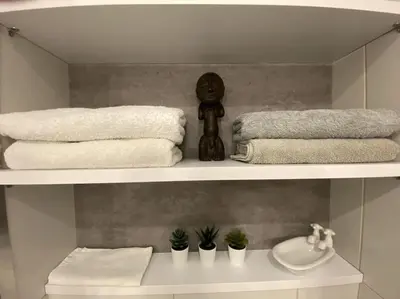 a bathroom with a shelf with towels and a sink at Ferienwohnung am Meer Belle Vue in Chania Town