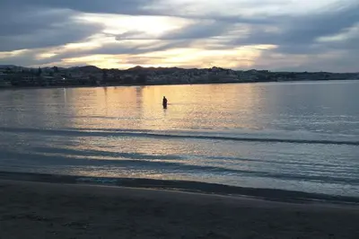 a person standing in the water at the beach at Ferienwohnung am Meer Belle Vue in Chania Town