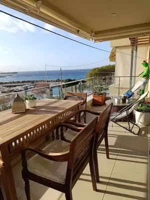 a patio with a wooden table and chairs on a balcony at Ferienwohnung am Meer Belle Vue in Chania Town