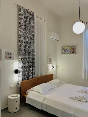 a white bedroom with a bed and a window at SQUARE 45 in Chania Town