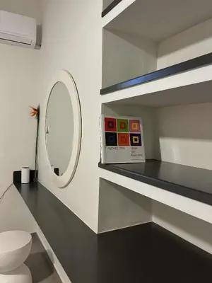 a bathroom with a toilet and a mirror on a shelf at SQUARE 45 in Chania Town