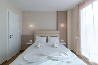 a bedroom with a white bed with a bow on it at Odyssey Residences in Chania Town