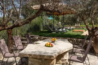 a stone table with a bowl of fruit on it at Klapas by PosarelliVillas in Chania Town