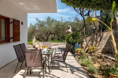 a patio with a table and chairs in a yard at Klapas by PosarelliVillas in Chania Town