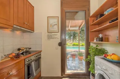 a kitchen with a door leading to a patio at Yiannis Cottage in Spiliá