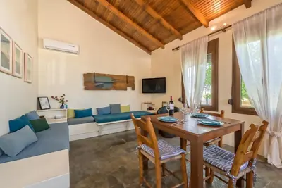 a living room with a table and chairs and a couch at Yiannis Cottage in Spiliá