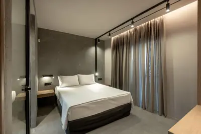 a small bedroom with a bed and a window at Zakro Luxury Living Chania in Chania Town