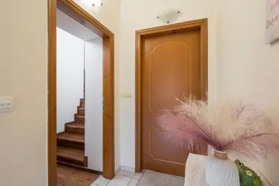 a hallway with a door and a vase with feathers at Lion's Yard in Chania Town