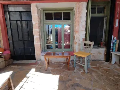 a table and a chair in front of a window at Chania Hostel Youth 18-50 in Chania Town