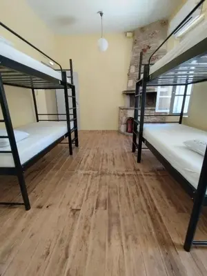 a room with two bunk beds and a wooden floor at Chania Hostel Youth 18-50 in Chania Town
