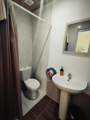 a small bathroom with a toilet and a sink at Chania Hostel Youth 18-50 in Chania Town