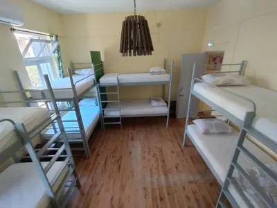 a room with four bunk beds and a chandelier at Chania Hostel Youth 18-50 in Chania Town