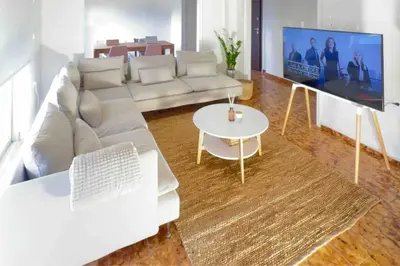 a living room with a white couch and a table at Linear Flat - City Center - Private Parking in Chania Town