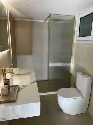a bathroom with a toilet and a shower and a sink at Linear Flat - City Center - Private Parking in Chania Town