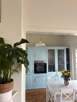 a kitchen with blue cabinets and a table with a plant at Linear Flat - City Center - Private Parking in Chania Town