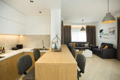 a kitchen and living room with a long wooden table at Kiss-ammos Apartments in Kissamos