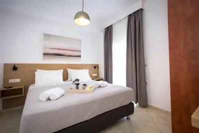 a bedroom with a bed with towels on it at Kiss-ammos Apartments in Kissamos