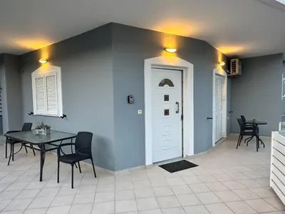 a dining room with a table and a white door at Glikanisos House Nipos - ideal for hikers and families 2bd, 6pl, 10min to beach in Nípos