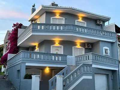 a blue house with white balconies and lights on it at Glikanisos House Nipos - ideal for hikers and families 2bd, 6pl, 10min to beach in Nípos