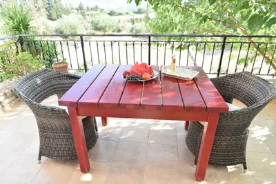 a wooden table and chairs with a bowl of fruit on it at apartment irini in Vryses