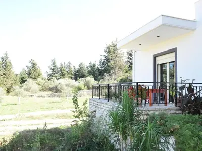 a white house with a porch and a balcony at apartment irini in Vryses