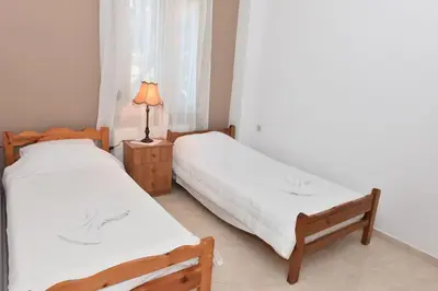 two beds in a bedroom with a lamp on a table at apartment irini in Vryses
