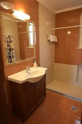 a bathroom with a sink and a shower and a mirror at apartment irini in Vryses