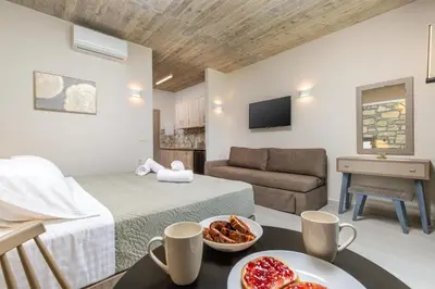 a room with a bed and a couch and a table at Achatis Apartments with sea view in Kolymvari