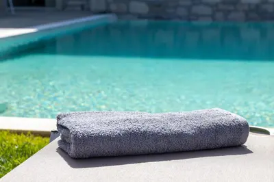 a towel sitting on a table next to a swimming pool at Achatis Apartments with sea view in Kolymvari