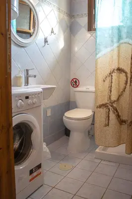 a bathroom with a washing machine and a toilet at Mamouth Studios in Chania Town
