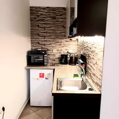 a small kitchen with a sink and a refrigerator at Mamouth Studios in Chania Town