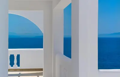a view of the ocean from a white building at Villa Chryssi in Tersanas