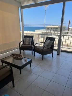 a living room with chairs and a table on a balcony at Nelly's Private Resindence in Chania Town
