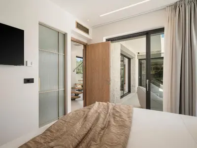 a bedroom with a bed and a sliding glass door at Villa Iocaste - With private pool and EV station in Chania Town