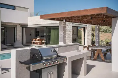 a outdoor kitchen with a grill and a patio at Villa Iocaste - With private pool and EV station in Chania Town