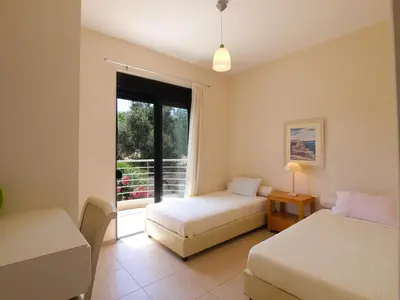 a bedroom with two beds and a window at Villa Bellissima in Chania Town
