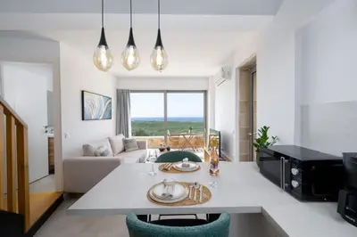 a kitchen and living room with a table and chairs at Anadia Luxury Pocket Villa Infinite Sea View in Falasarna